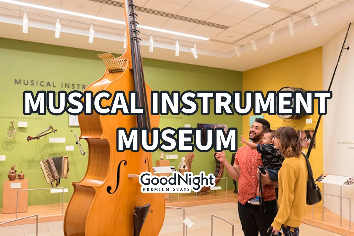 This image captures a vibrant interior scene at the Musical Instrument Museum, featuring a large musical instrument, families interacting with engaging exhibits, and lively wall colors. The atmosphere is curious, joyful, and educational, emphasizing hands-on exploration and cultural discovery.