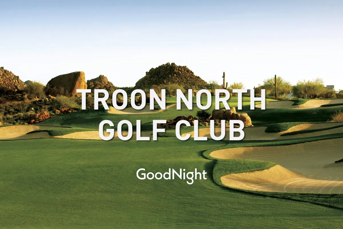 A panoramic view of a tranquil golf course nestled among striking rock formations and lush green grass. The scene exudes peacefulness and invites viewers to imagine golfing or relaxing in a picturesque outdoor setting.