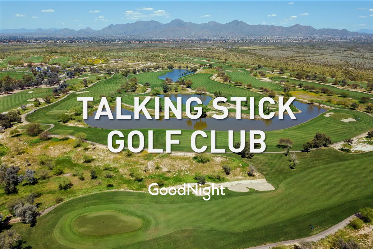 A scenic golf course featuring expansive green lawns, water features, and a striking mountain view in the background. The tranquil open space evokes the natural beauty of the local area.